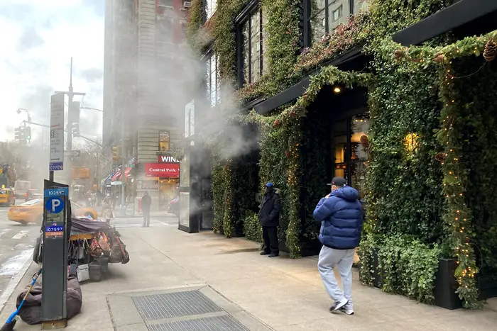 A photo of someone walking past smoke on 57th Street
